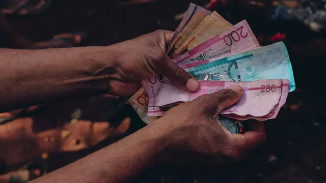 Hombre sostiene billetes.
