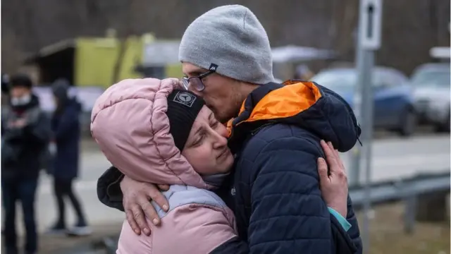 यूक्रेन पोलैंड सीमा पर गल मिलकर अलविदा कहता एक जोड़ा.