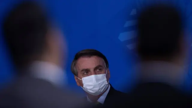 De máscara, Bolsonaro olha para o lado em evento