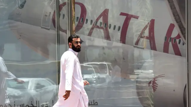 ชายคนหนึ่งเดินผ่านสำนักงานสายการบินในกาตาร์