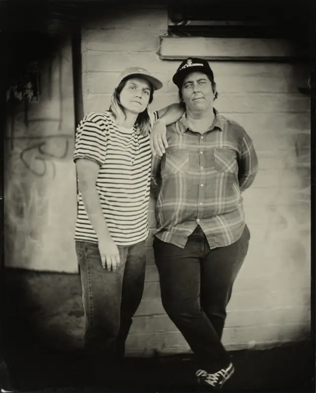 Портрети две особе наслоњене на зид