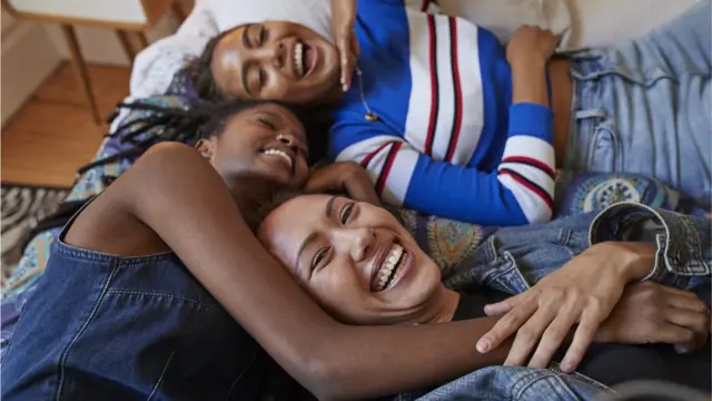 Tres mujeres en una cama.