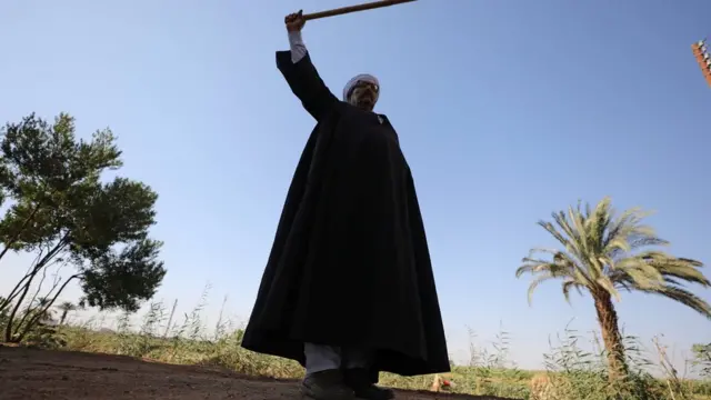 رجل يرقص بالعصا