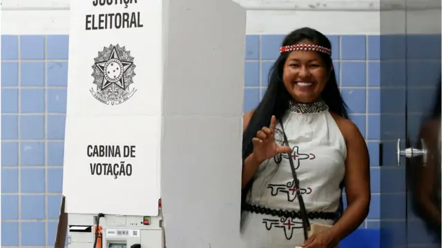 An indigenous Kambeba woman gestures after casting her vote during the legislative and presidential election, in Brazil, on October 2, 2022