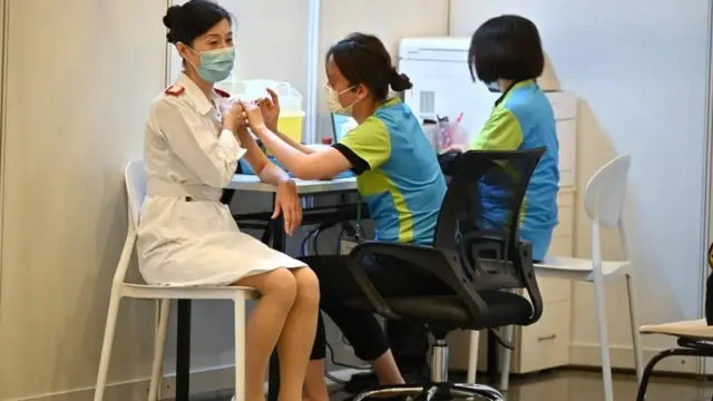 COVID-19 vaccination program in Hong Kong: A health care worker is given a COVID-19 vaccination at a clinic in Hong Kong, China, 23 February 2021