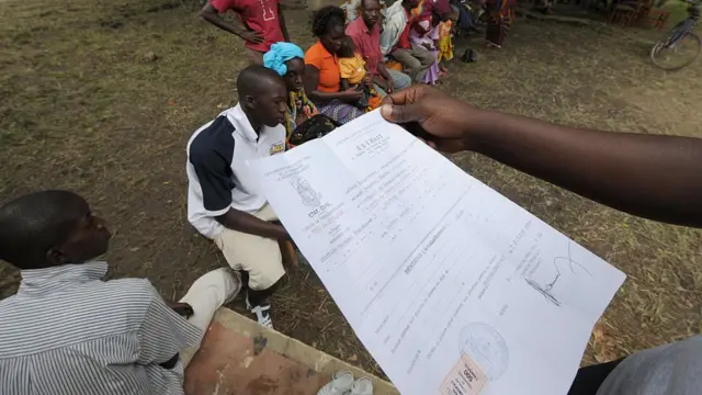 Un employeur de la société Sagem (R) vérifie un acte de naissance le 16 septembre 2008 à Ferkessedougou lors du deuxième jour de l'enregistrement électoral dans le pays.