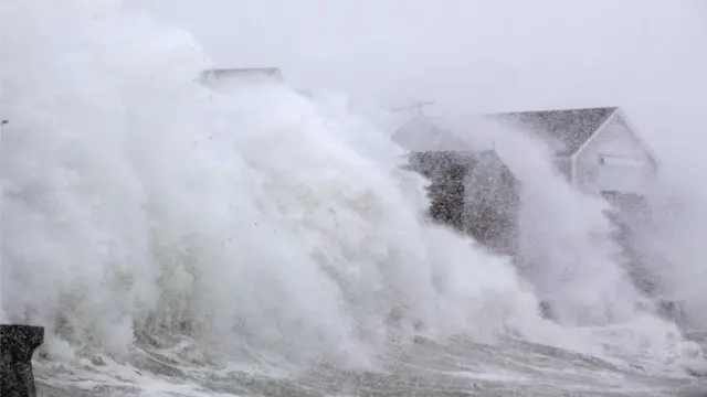 Una ola golpea una casa en Scituate, Massachusetts