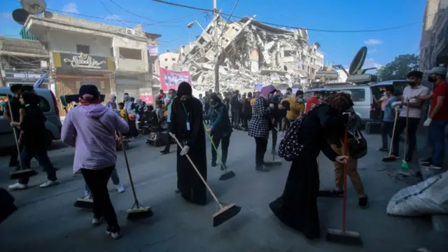 ГАЗА, ПАЛЕСТИНА - 2021/05/23: Волонтери прибирають вулиці в торговому районі Аль-Ремаль у місті Газа, нещодавно обстріляному ізраїльськими авіаударами.