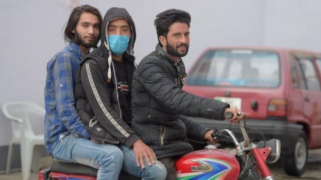 Homens em moto, um deles com máscara, no Paquistão