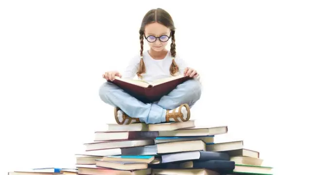 Girl sitting with books surrounded