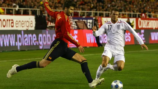Piqué patea el balón ante la marca de David Beckham.