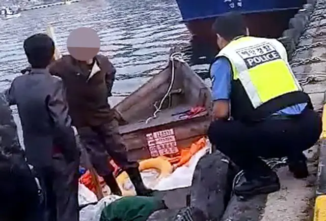 삼척항 부두에 정박한 북한어선과 어민이 경찰에 조사받는 모습