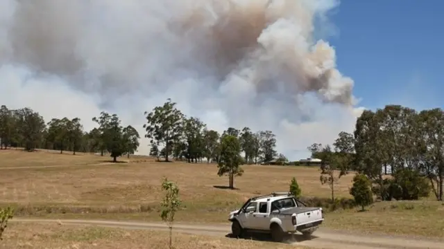 A car drives in front of smoke