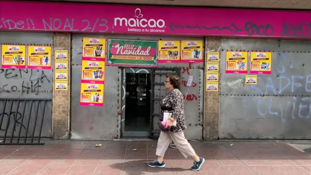 Mujer pasa frente a un comercio en Valparaíso