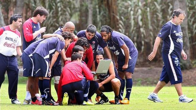 Members of the Chilean national football team huddle around a laptop as coach Marcelo Bielsa (R) walks away from the group during a training session at the Liga de Quito sports complex in Quito on October 8, 2008,. Chile will face Ecuador on October 12 in a FIFA World Cup South Africa-2010 qualifier match. AFP PHOTO/MARCO MUGA (Photo credit should read MARCO MUGA/AFP via Getty Images)