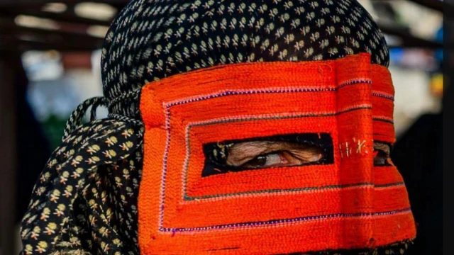 मास्क पहनी हुइ एक ईरानी बंदारी महिला