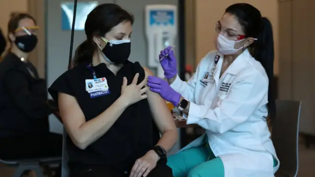 મહિલાને રસી આપતાં એક નર્સ