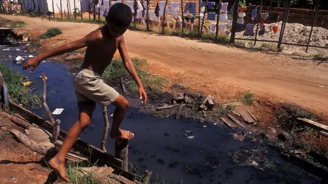 Criança ao ladojogo infantil grátisesgoto ao céu abertojogo infantil grátisNatal, no Rio Grande do Norte