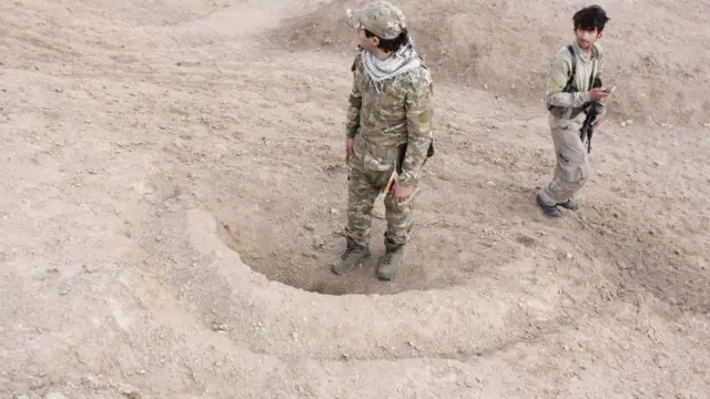 جنديان يقفان على حفرة