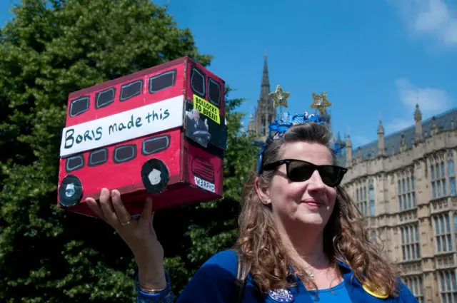 Une manifestante anti-Brexit se moquant du principal hobby de Boris Johnson : la création de bus miniatures avec de vieux cageots de vin, le 26 juin 2019.