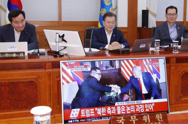 South Korean President Moon Jae-in (C) and Prime Minister Lee Nak-yon (L) watch a television screen showing the summit between US President Donald Trump and North Korean leader Kim Jong Un during a Cabinet meeting at the presidential Blue House in Seoul on June 12, 2018. Donald Trump and Kim Jong Un have become on June 12 the first sitting US and North Korean leaders to meet, shake hands and negotiate to end a decades-old nuclear stand-off. / AFP PHOTO / YONHAP / YONHAP / - South Korea OUT / REPUBLIC OF KOREA OUT NO ARCHIVES RESTRICTED TO SUBSCRIPTION USE YONHAP/AFP/Getty Images
