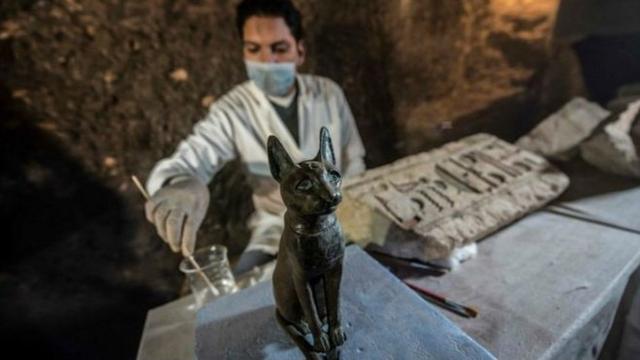 一名埃及考古學家為猫女神的青铜雕像清理