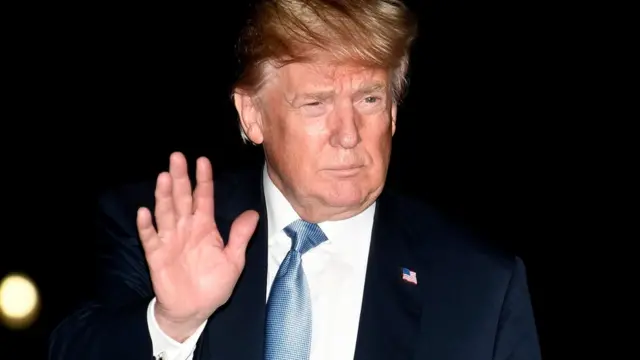 President Donald Trump waves to the press on his arrival at the White House