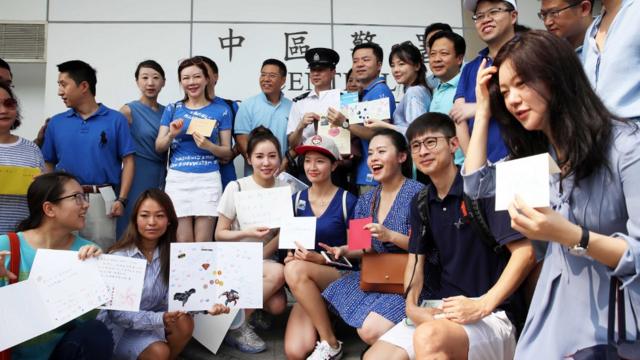 香港上环中区警署身穿蓝色上衣的亲北京群众向警署代表送上心意卡（中新社图片10/8/2019）