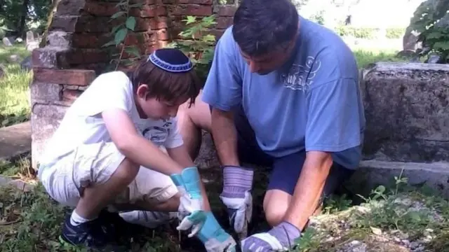 Grant Gochina Myahudi ambaye mababu zake waliuawa na Noreika akiwa katika makaburi nchini Lithuania