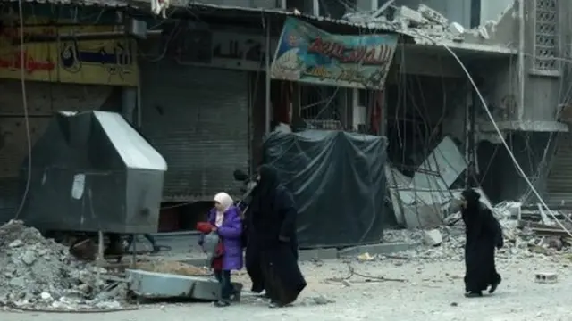 Syrian women run for cover following Syrian government bombardment on the town of Douma in the rebel-held enclave of Eastern Ghouta on the eastern outskirts of the capital Damascus on March 10, 2018.