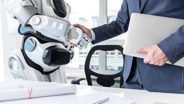 Hombre y robot dándose la mano