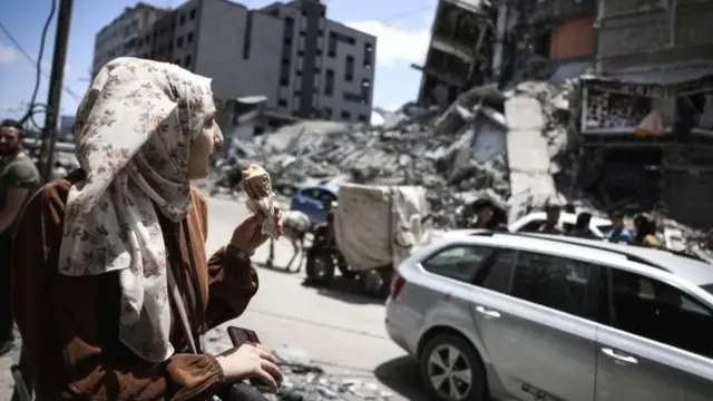 ધ્વસ્ત થયેલા ગાઝા વચ્ચે આઇસક્રીમ ખાતી યુવતી