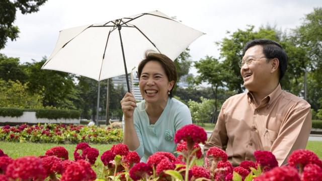 Una mujer asiática cubriéndose del sol junto a un hombre