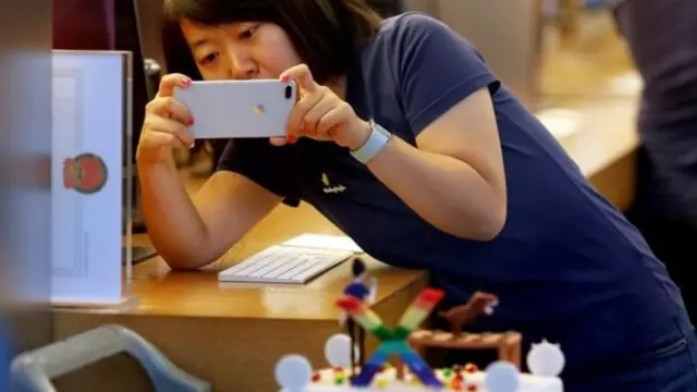 سيدة صينية تستخدم أيفون للتصوير