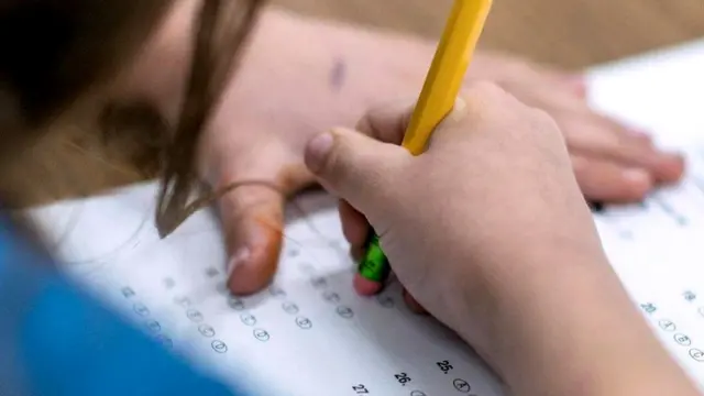 Девочка выполняет задание в школе