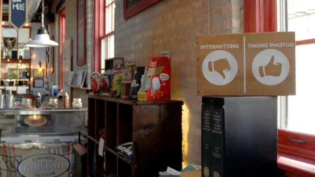 صورة لأحد المقاهي يعلق لافته لا تشجع على استخدام الإنترنت