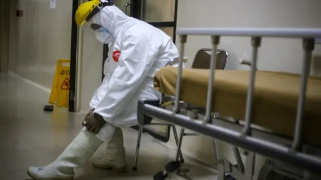 Seorang tenaga kesehatan menggunakan alat pelindung diri lengkap saat jam pertukaran shift di rumah sakit rujukan COVID-19 RSUD Kabupaten Tangerang, Banten, Senin (13/07).