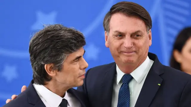 O ex-ministro Nelson Teich abraçado ao presidente Jair Bolsonaro, que tem um meio sorriso no resto,bot aviator realsbetfoto antes da demissão