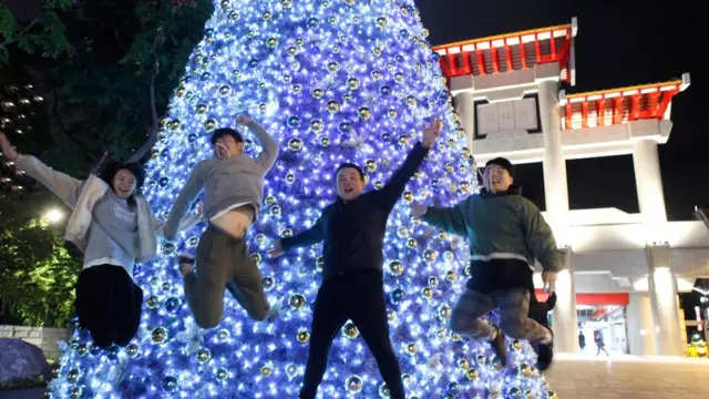 台湾的一些年青人在圣诞树前玩耍摆拍