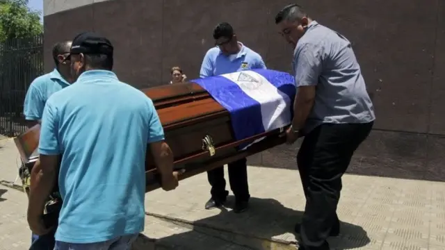 Hombres llevan un ataúd