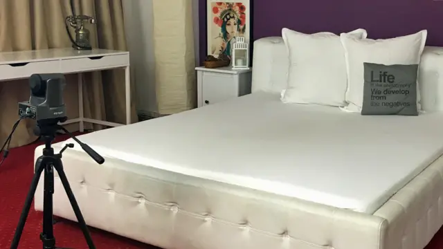 Una cama y una cámara en uno de los cuartos de Studio 20
