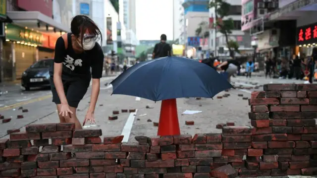 Una manifestante construye un muro