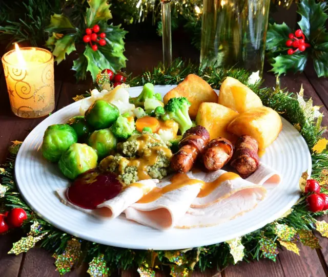 A traditional English Christmas dinner. Turkey Brussels sprouts roast potato potatoes stuffing pigs in blankets