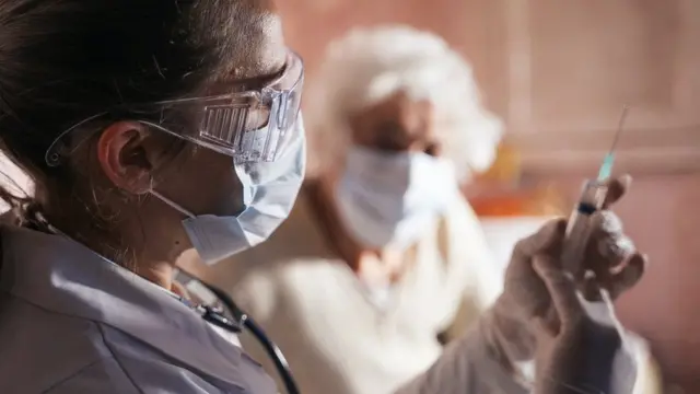 একজন ডাক্তার টিকা দেওয়ার প্রস্তুতি নিচ্ছেন।