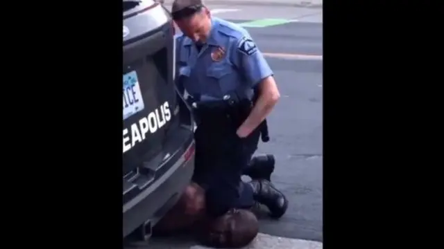 လူမည်းအမျိုးသားရဲ့ လည်ပင်းကို လူဖြူ ရဲအရာရှိတစ်ဦးက ဒူးခေါင်းနဲ့ တက်ကြိတ်ပြီး မေးမြန်းခဲ့