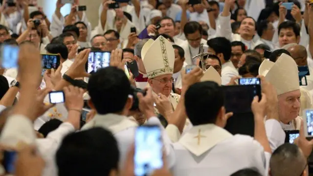 Una aglomeración de gente que toma fotos del Papa Francisco