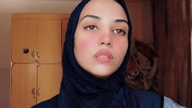 Farida usa o véu islâmico enquanto gravando vídeo na casa dela