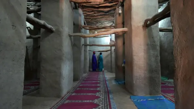 Dua jemaat Muslim bercakap-cakap di dalam masjid di Kong