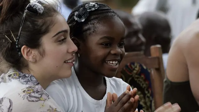 Lourdes, la fille naturelle de Madonna, tenant dans ses bras Mercy James, la fille adoptive de la star, originaire du Malawi.