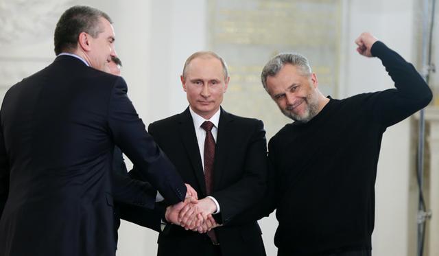 Crimean Prime Minister Sergei Aksenov, Russian president Vladimir Putin, and Sevastopol head Alexei Chalyi (L-R) join hands after signing an interstate unification agreement between the Russian Federation, the Republic of Crimea and the city of Sevastopol. Under the terms of the agreement, the Republic of Crimea and Sevastopol become federal subjects of the Russian Federation. MARCH 18, 2014.